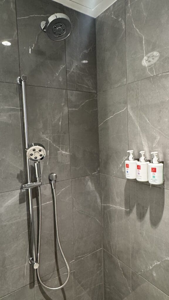 a shower with a shower head and soaps