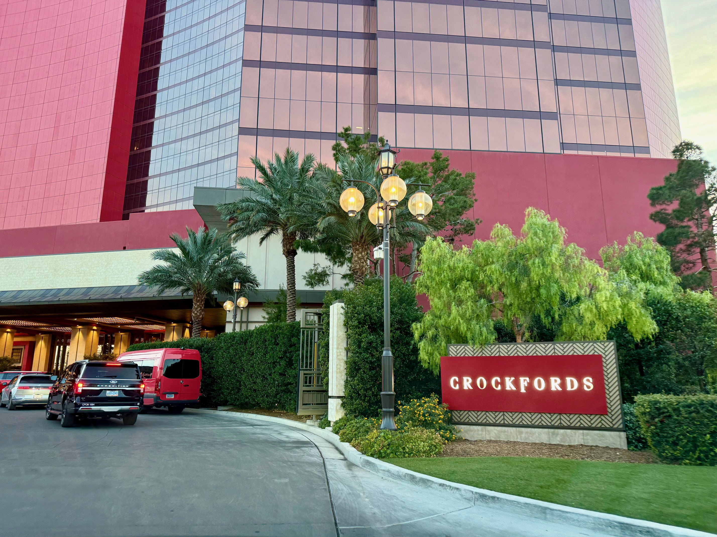 a building with a red sign and palm trees