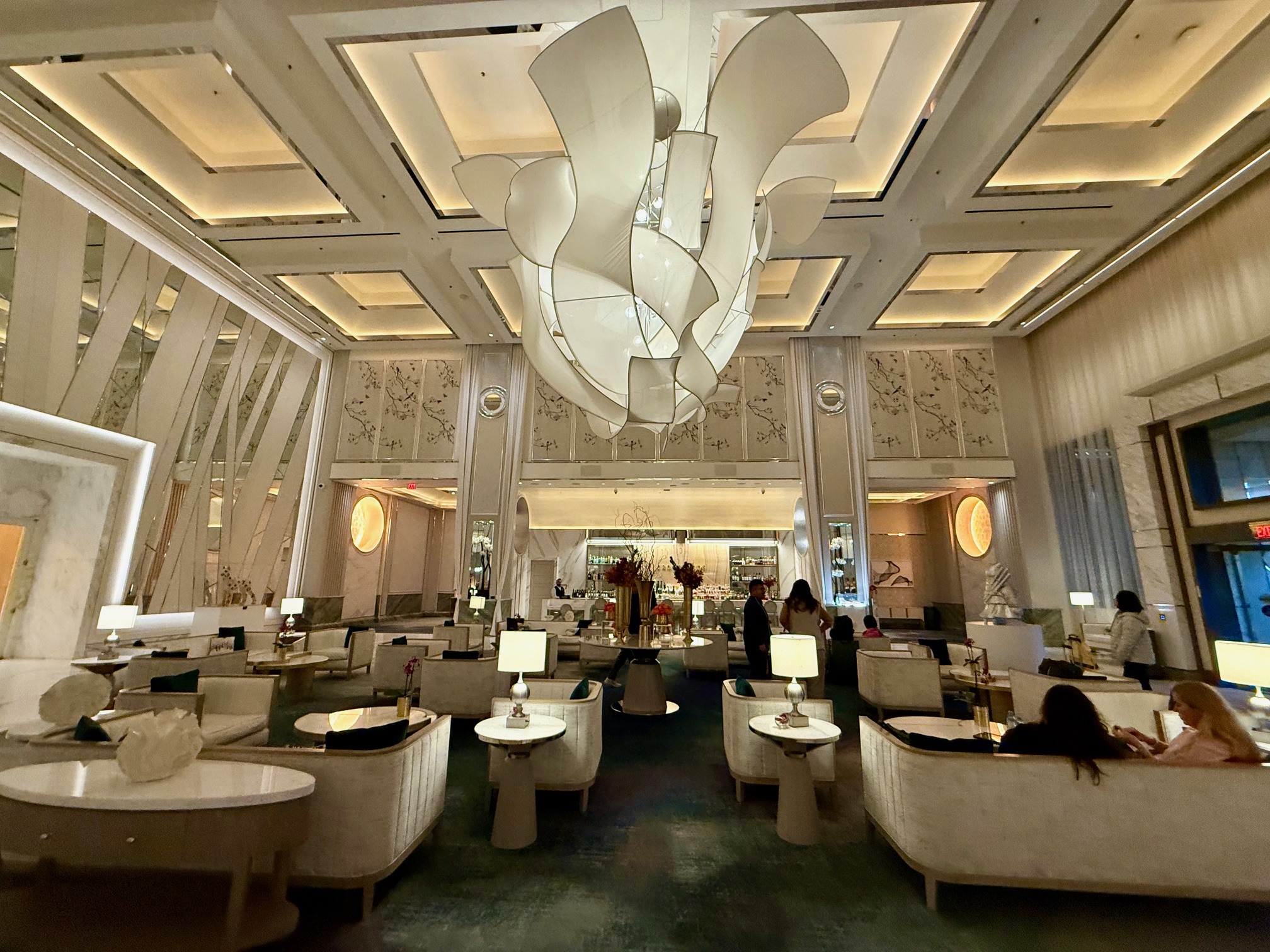 a room with white furniture and a chandelier at the Crockfords Las Vegas