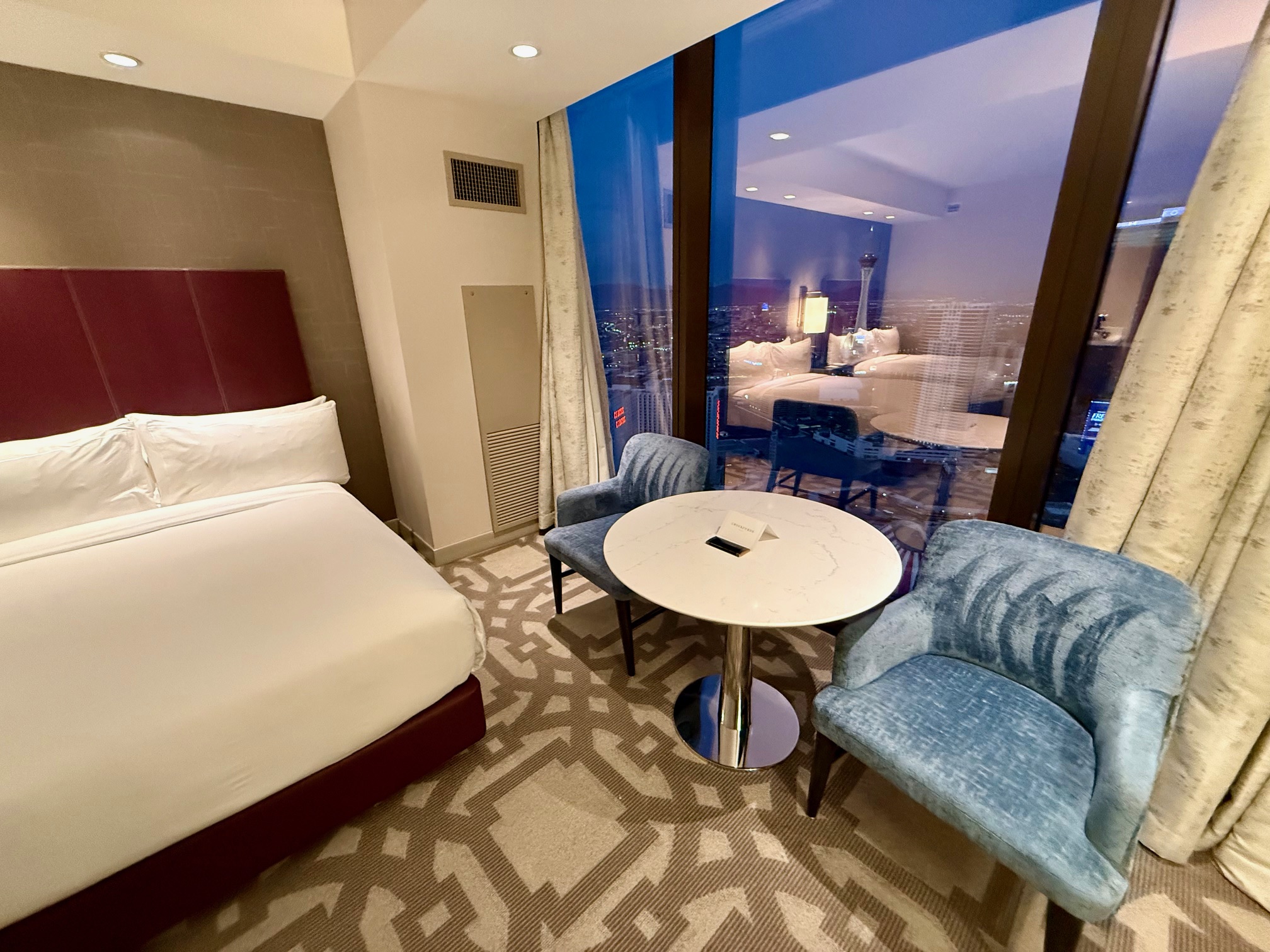 a room with a bed and chairs