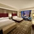a hotel room with two beds and a table at the Crockfords Las Vegas