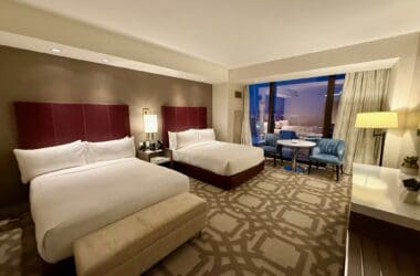 a hotel room with two beds and a table at the Crockfords Las Vegas
