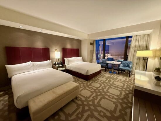 a hotel room with two beds and a table at the Crockfords Las Vegas