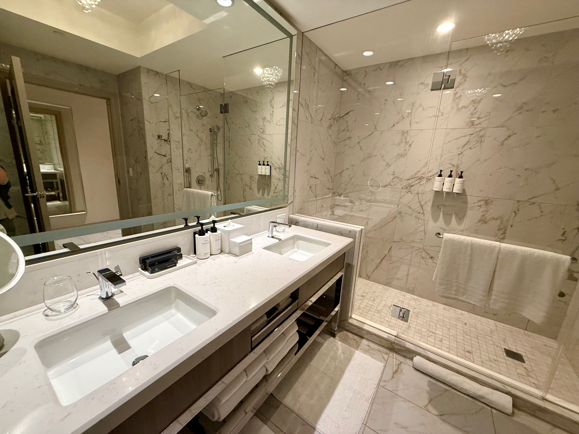 a bathroom with marble tile floor and a large mirror at the Crockfords Las Vegas