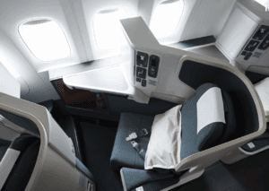an airplane seat with a pillow and a table