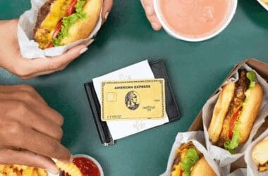 An image showing an American Express Gold Card on a table next two burgers and fries