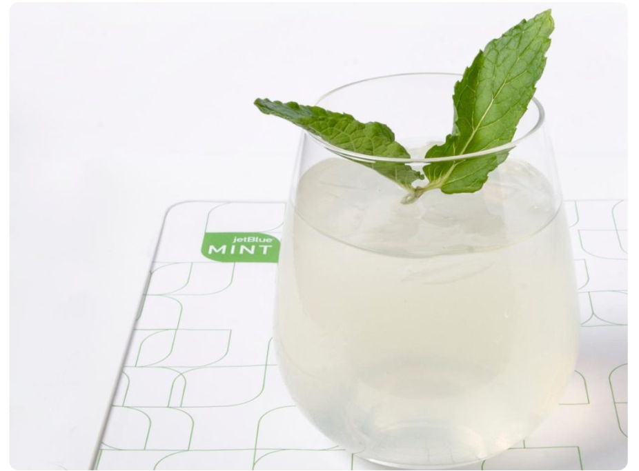 A Mint Condition cocktail on a tray with JetBlue Mint branding
