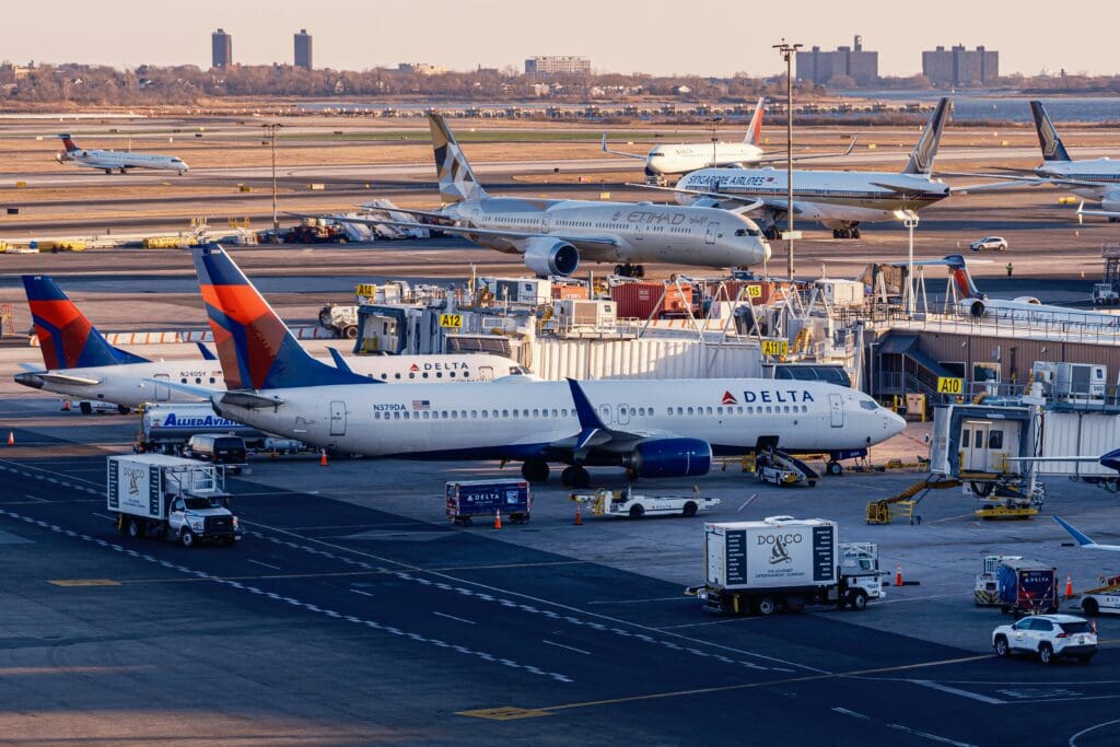 Various aircraft operated by Delta, Etihad Airways, and Singapore Airlines at New York-JFK Airport