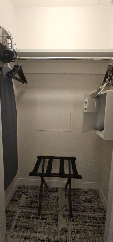 a closet with a shelf and a chair