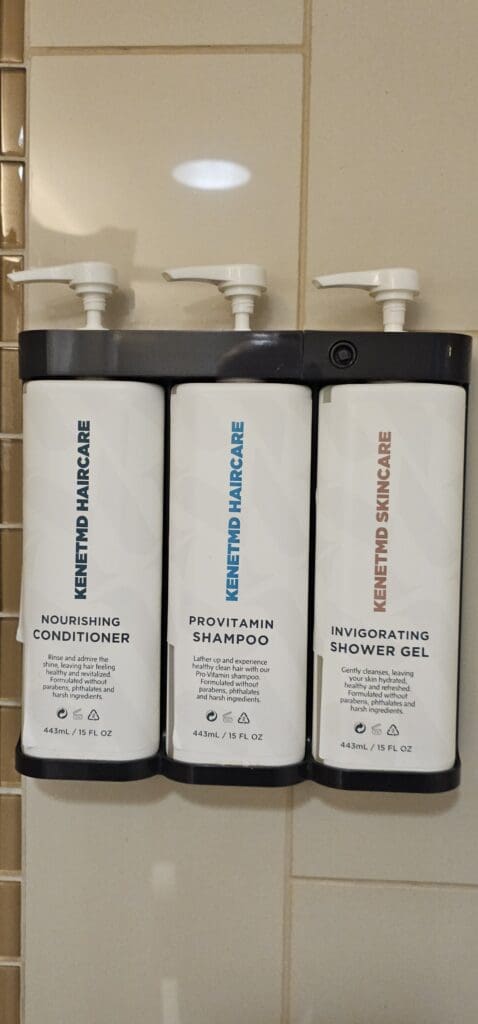 a group of white bottles with black labels on a black shelf