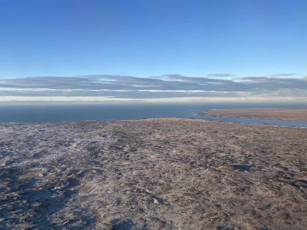 a large flat land with water in the background