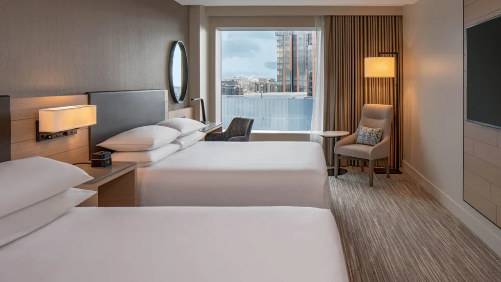 a hotel room with two beds and a chair