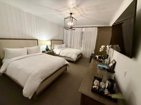 a bedroom with two beds and a tv at the Vespera Resort Pismo Beach