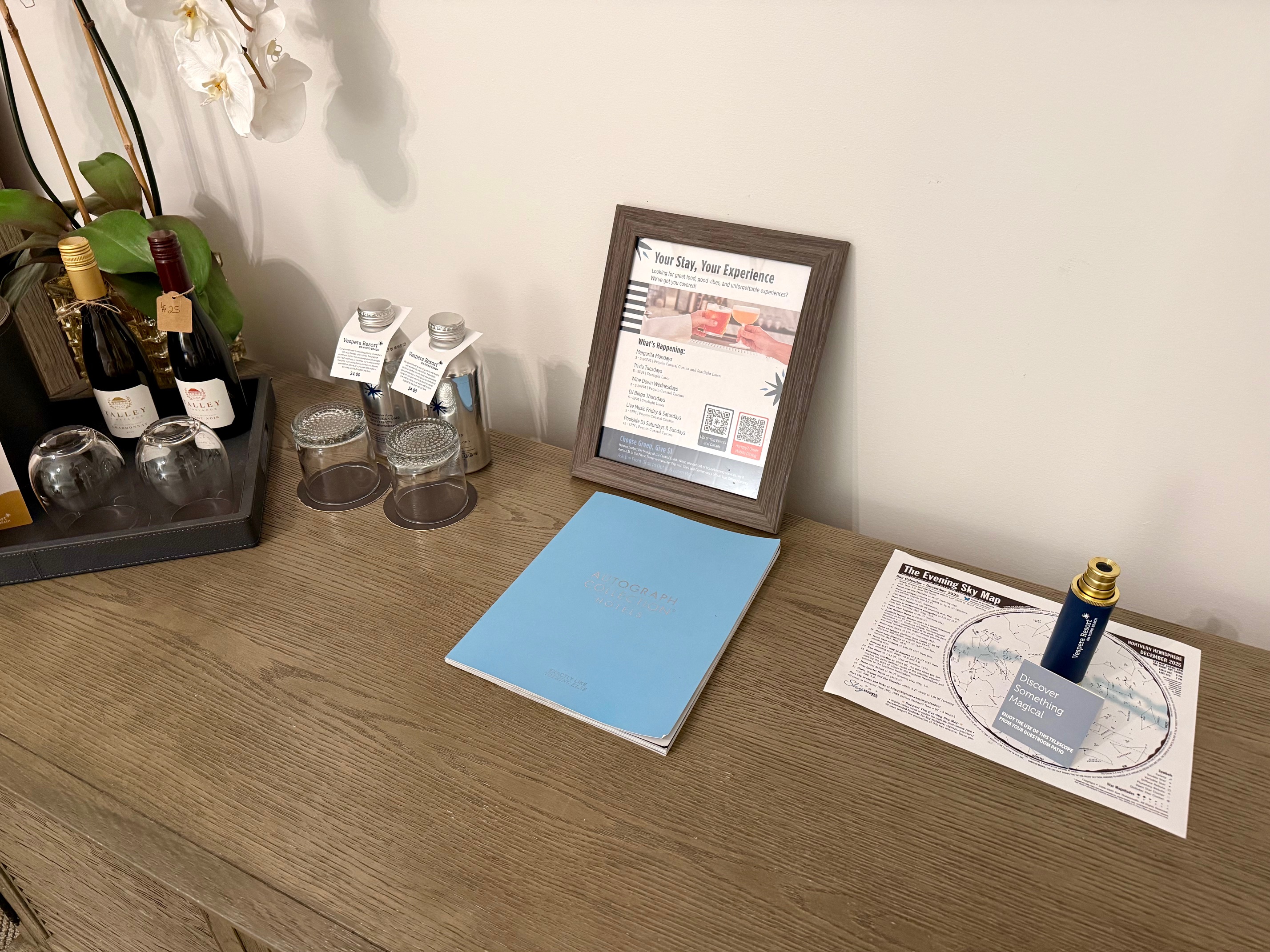 a table with a picture frame and glasses and a bottle of wine