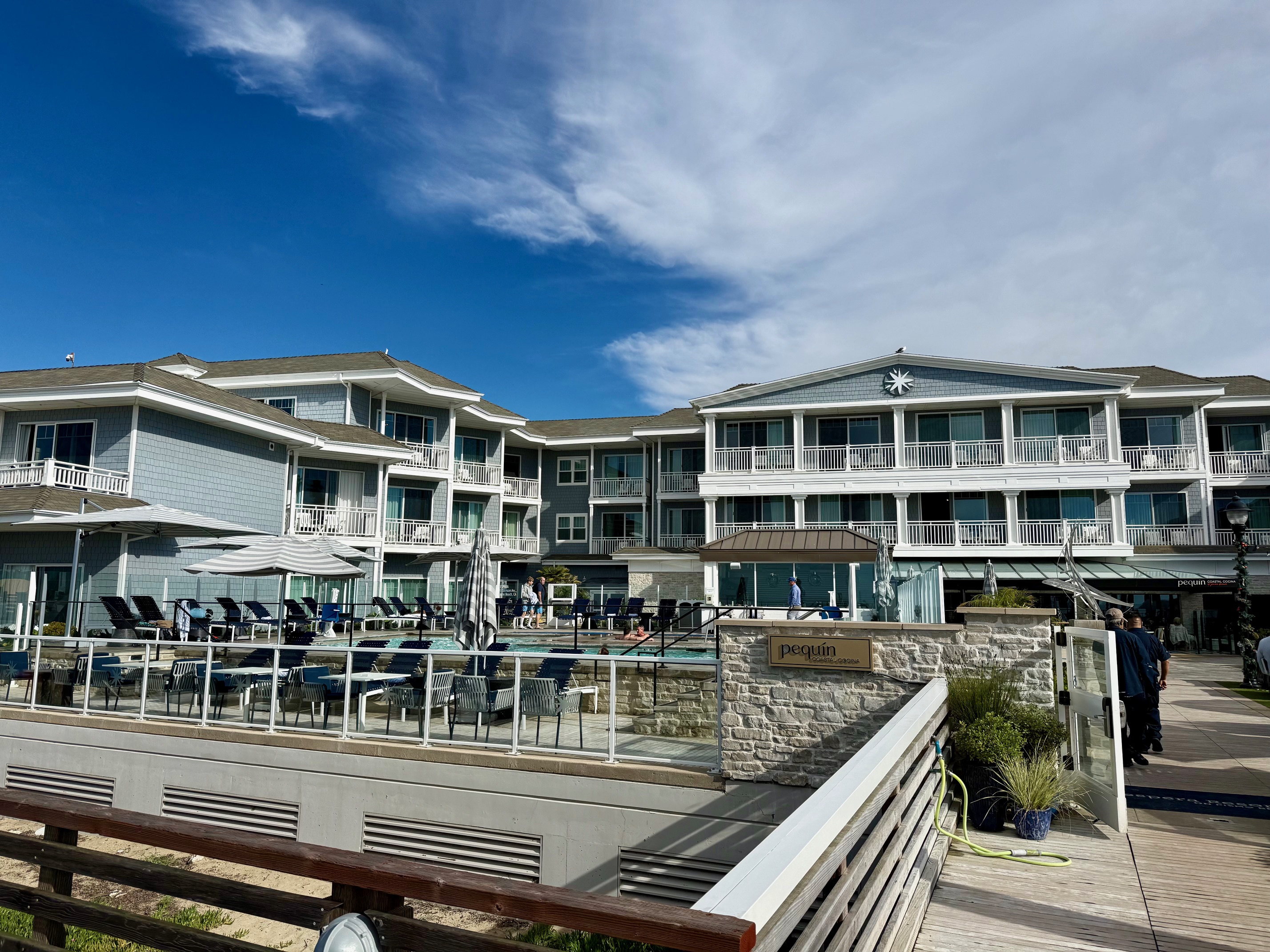 a building with a pool and chairs at Vespera Resort
