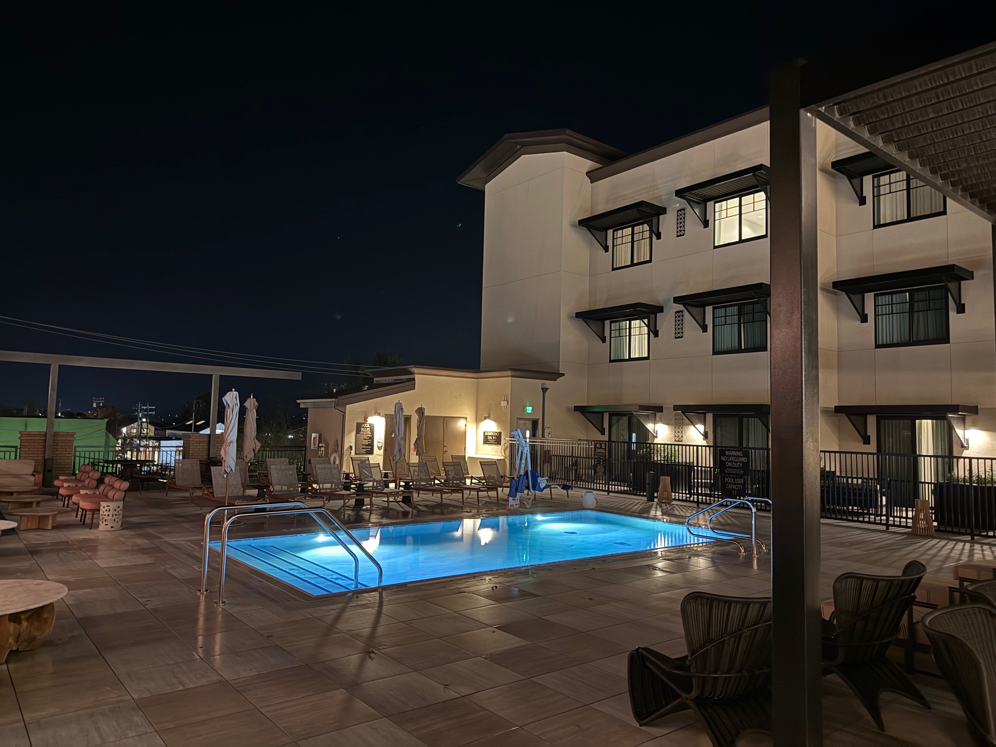 a pool with a deck and chairs in front of the Ava Hotel Paso Robles
