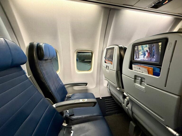 seats on an United 737-900ER with a television screen
