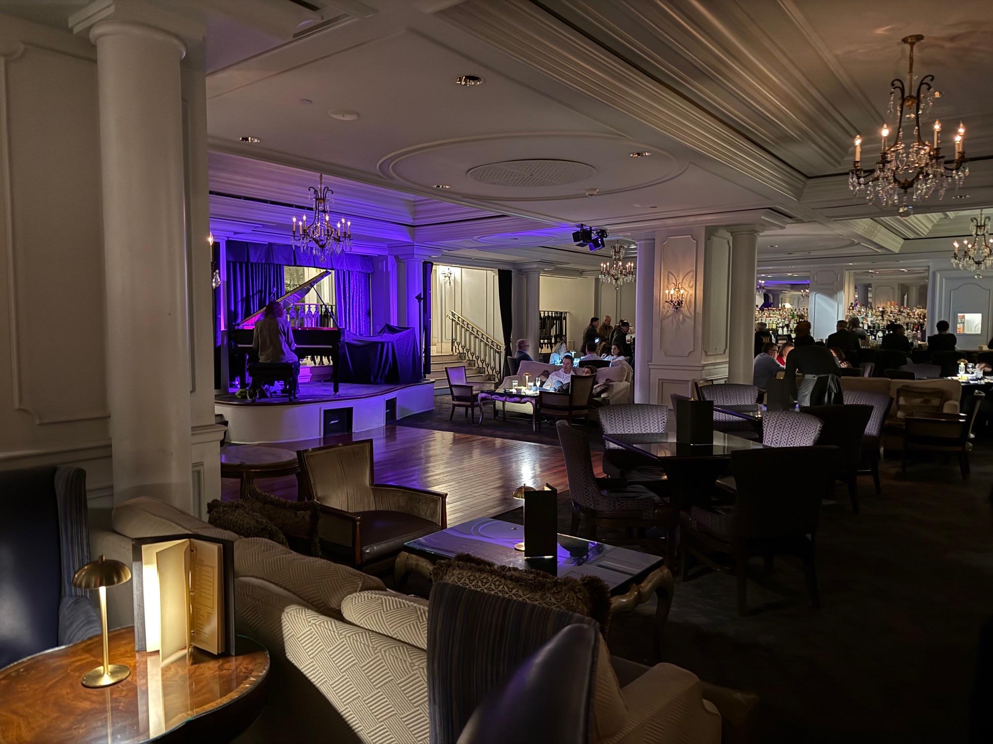 a room with a stage and chairs and a piano