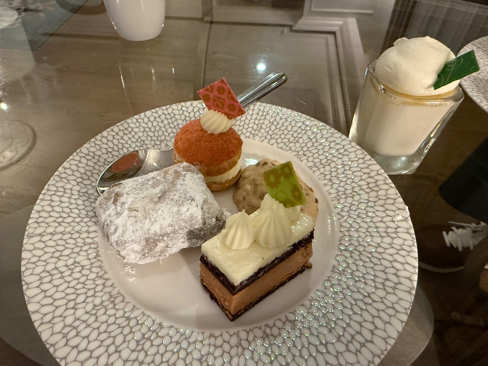 a plate of desserts on a glass table