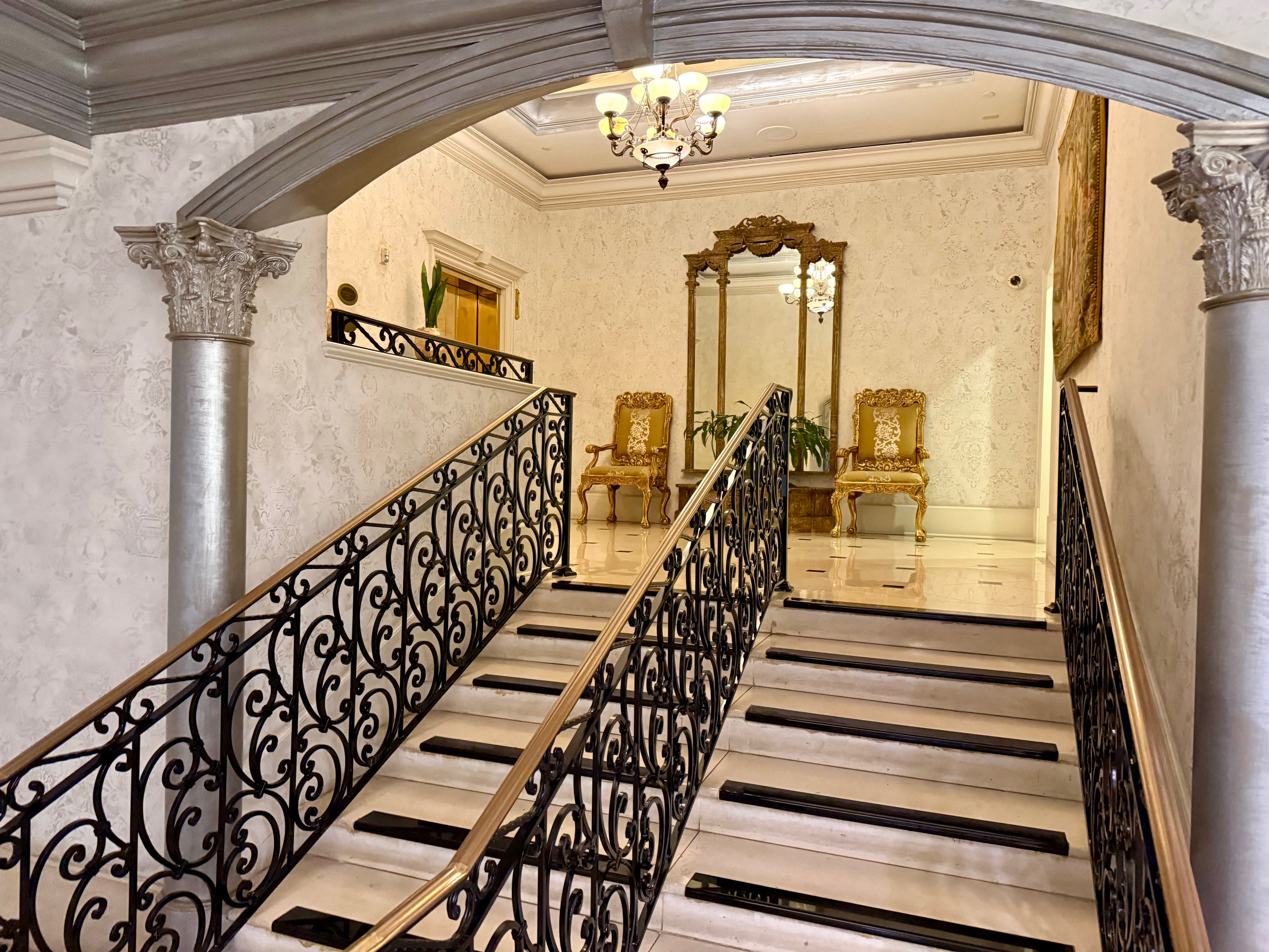 a staircase with a mirror and chairs