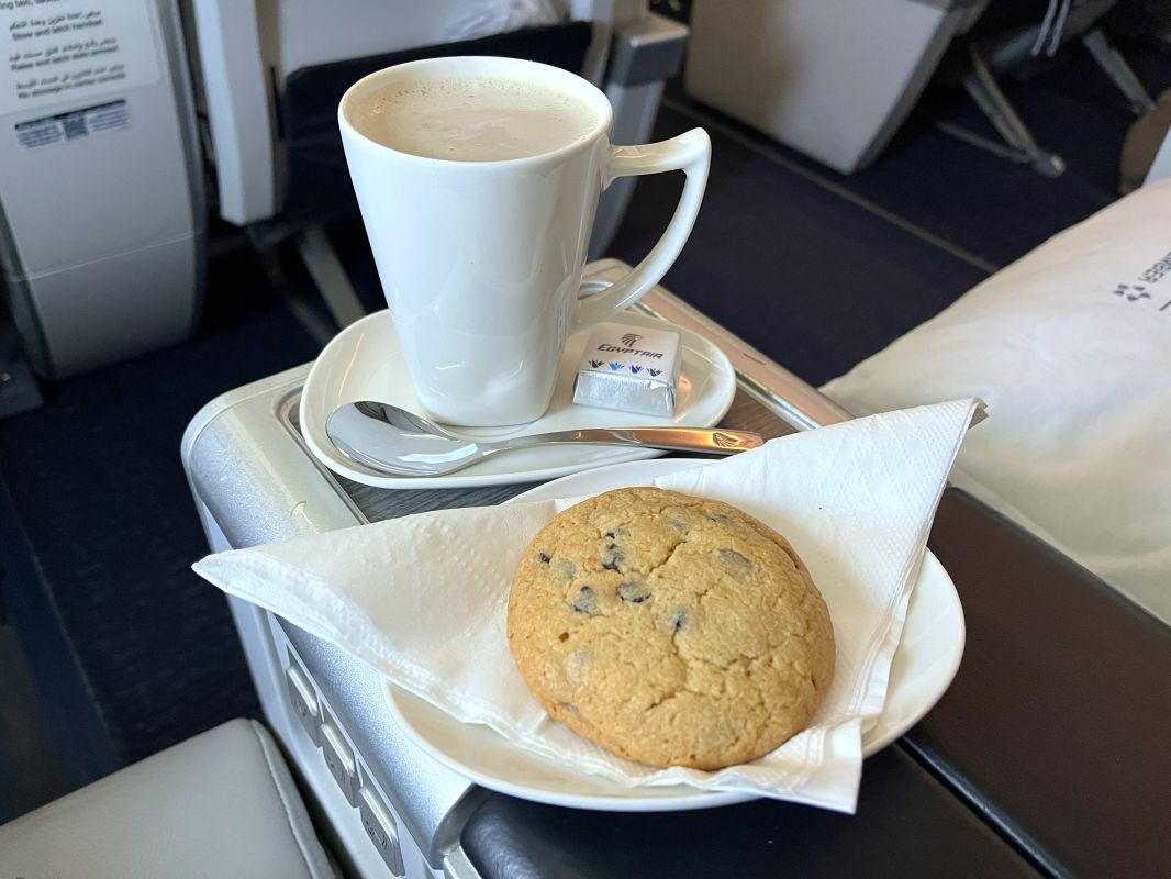 a plate of food and a cup of coffee on a tray
