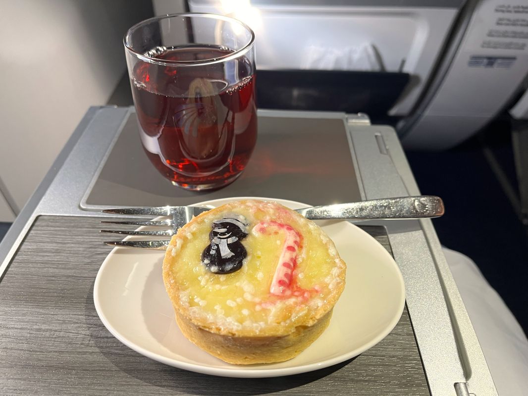 a plate with a pastry on it and a glass of liquid on a tray