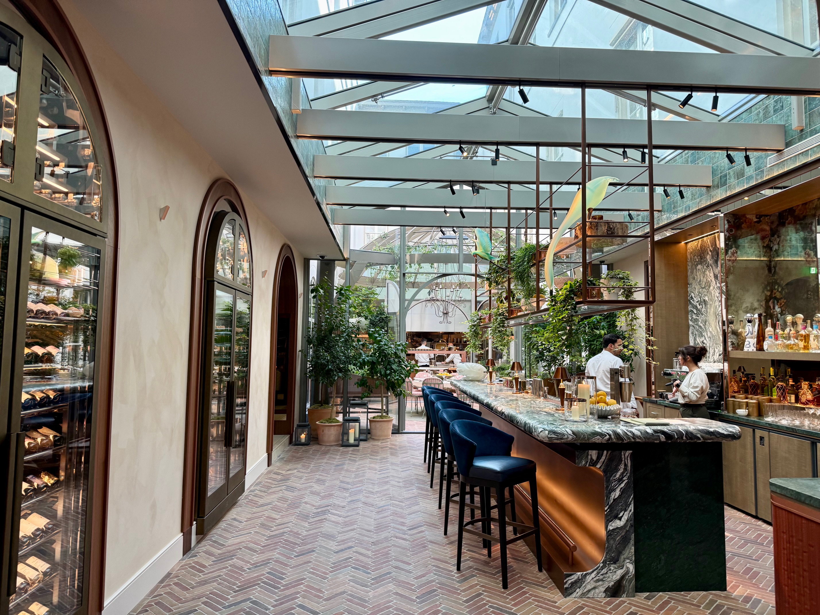 a bar with chairs and a glass roof at the Rosewood Amsterdam