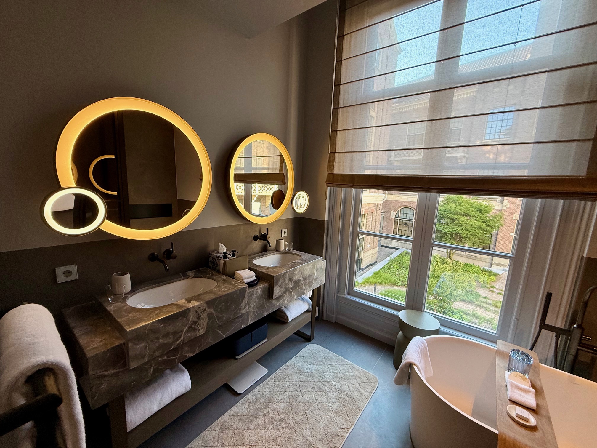 a bathroom with a tub and two mirrors at the Rosewood Amsterdam