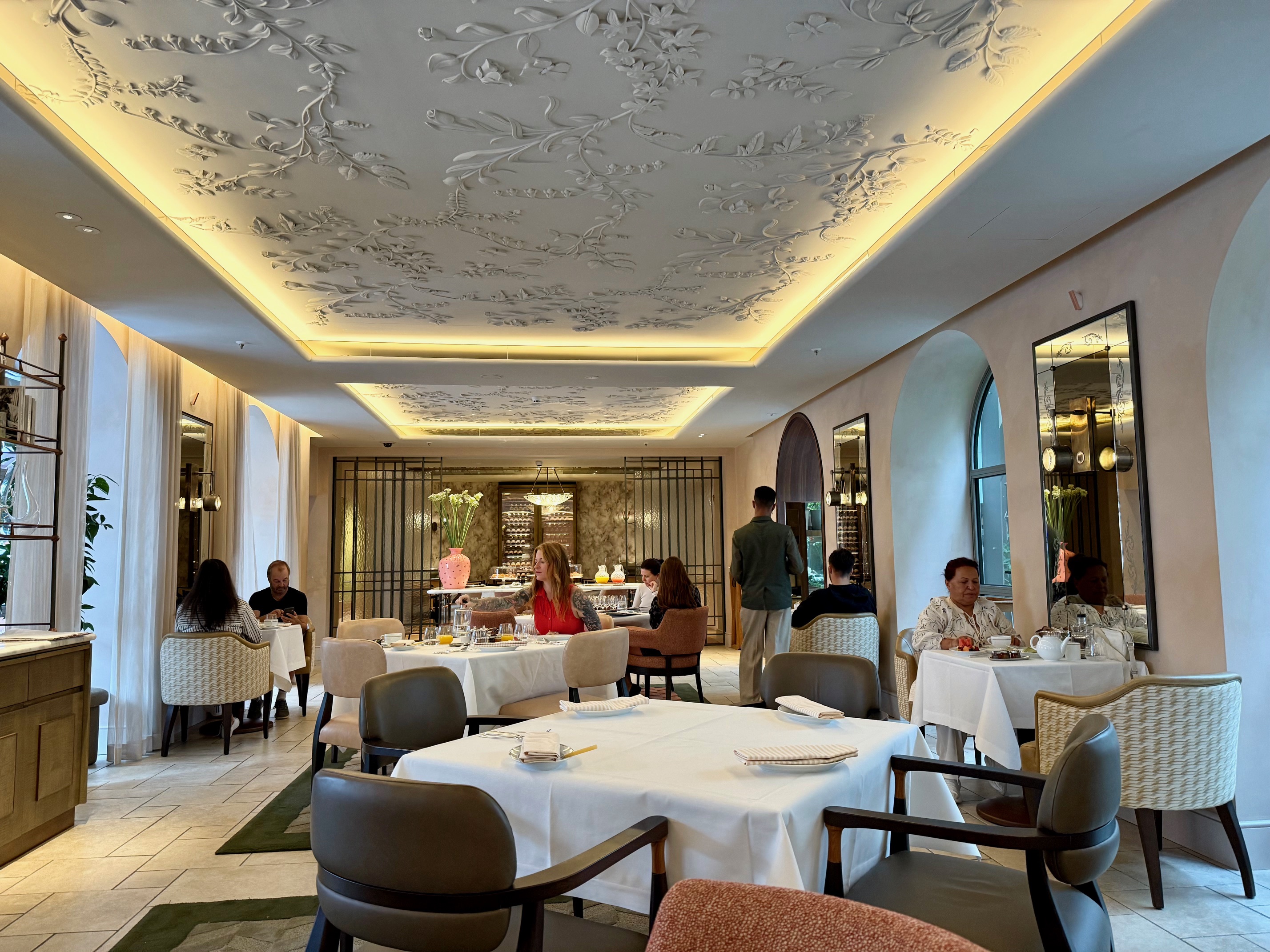 a room with tables and chairs and a ceiling with a decorative ceiling