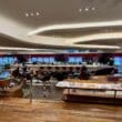 a large room with a large counter and tables at the Virgin Atlantic Clubhouse London