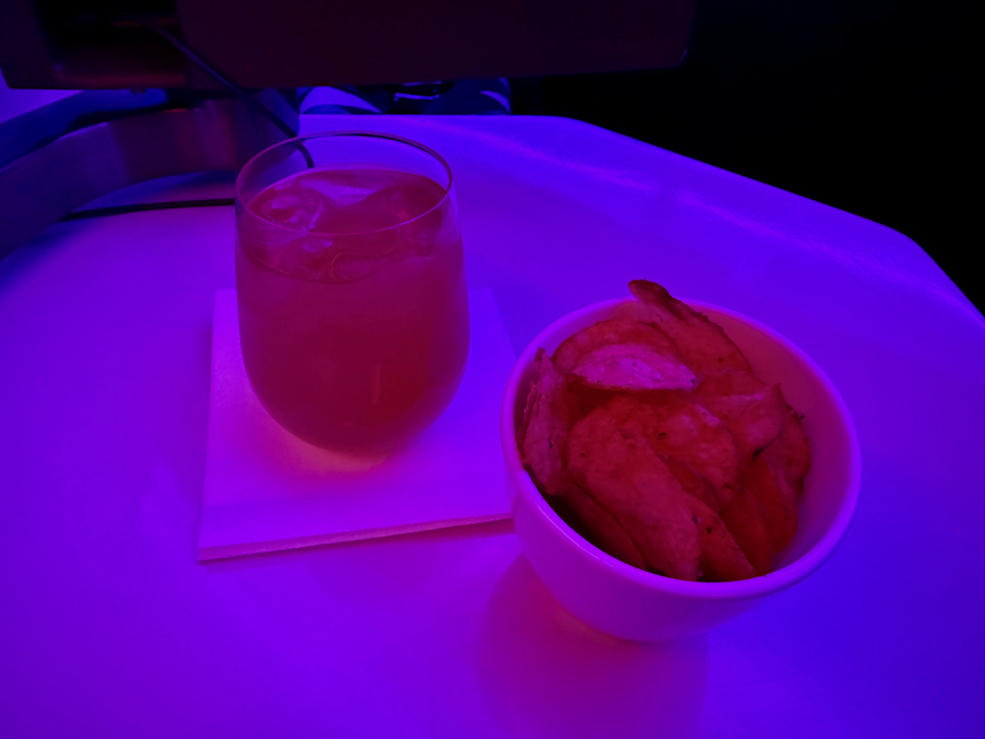 a bowl of chips and a drink on a table