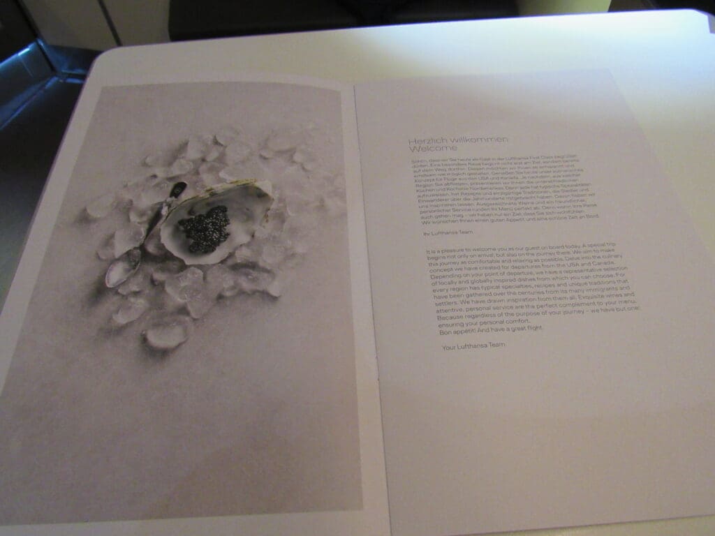 a book open with a spoon and a bowl of black caviar