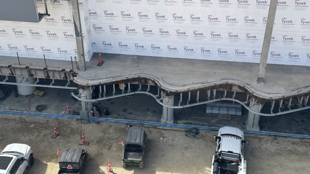 cars parked cars under a construction site