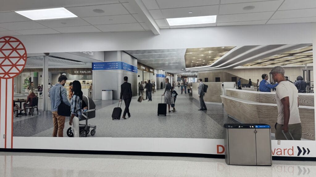 a large billboard with people walking in an airport
