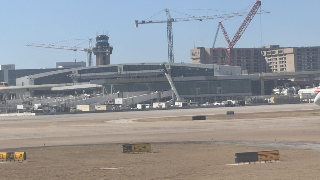 a large building with cranes in the background