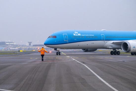 a blue airplane on a runway