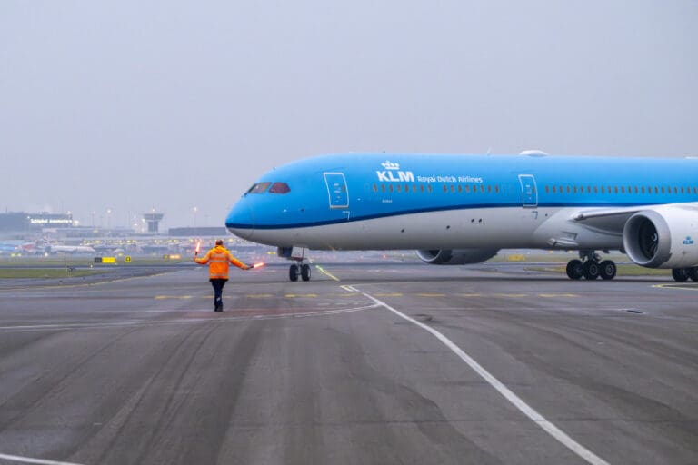 a blue airplane on a runway