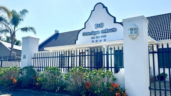 a white building with a fence and flowers