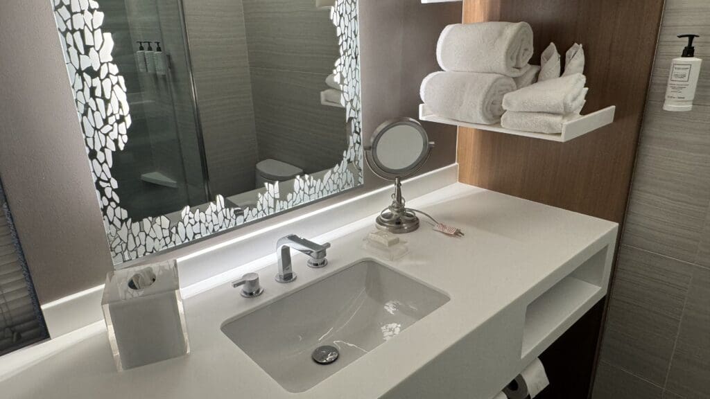 a bathroom sink with a mirror and towels