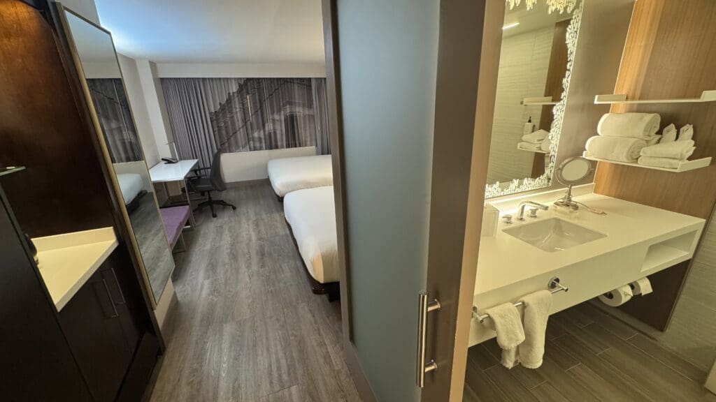 a room with two beds and a sink