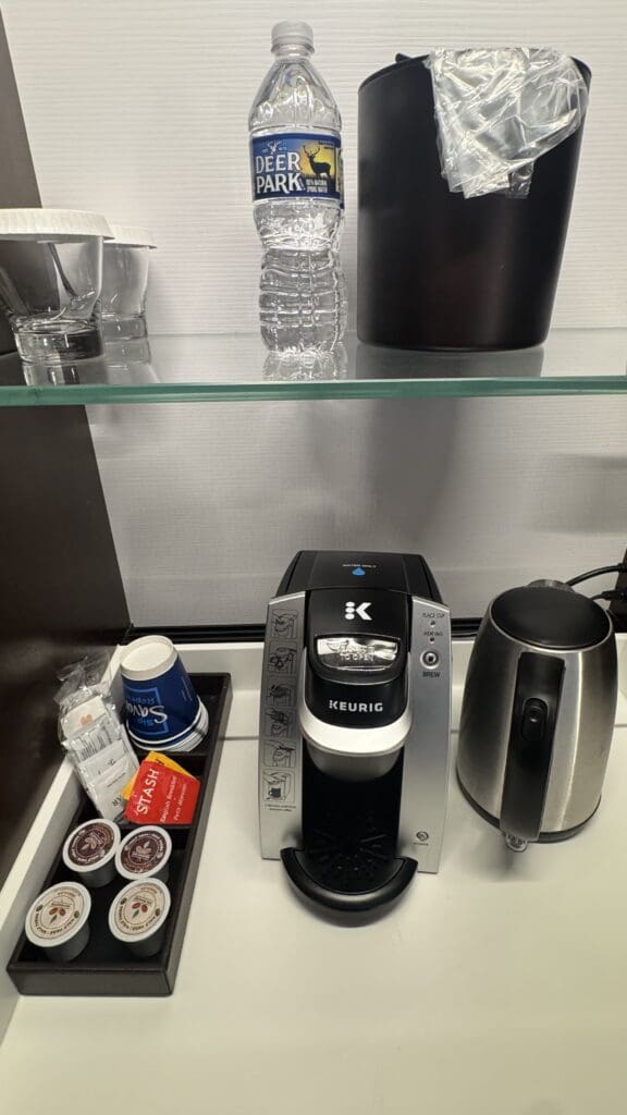 a coffee maker and coffee pot on a shelf